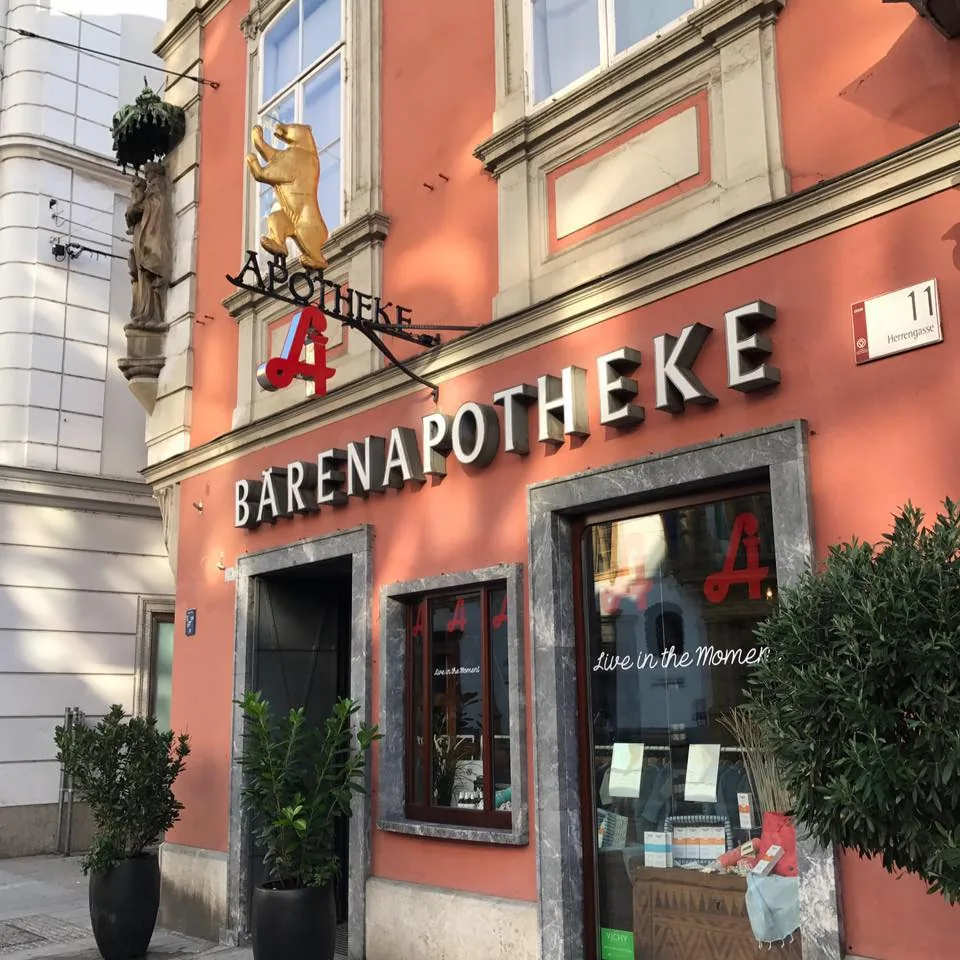 Fassade der Bärenapotheke in der Herrengasse 11 mit Schriftzug „Bärenapotheke“, goldenem Bären und Apotheken-A