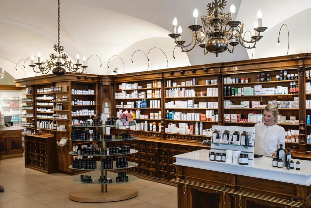 Historische Offizin der Bärenapotheke mit Gewölbedecke, Kristalllustern und dunklen Holzregalen